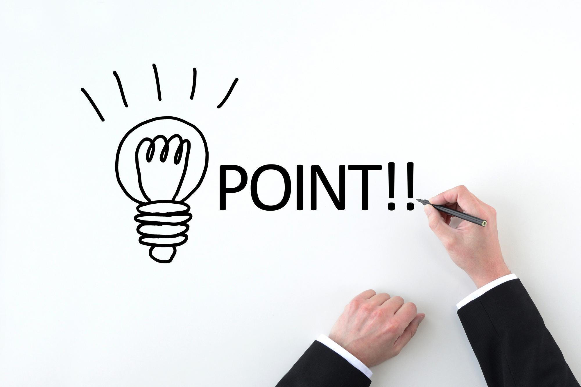 白の背景に豆電球と「POINT」と書いているペンを持つ手