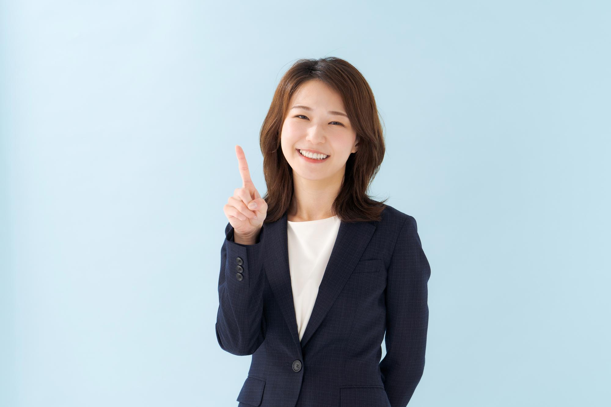 人さし指を立てて笑顔を向ける女性
