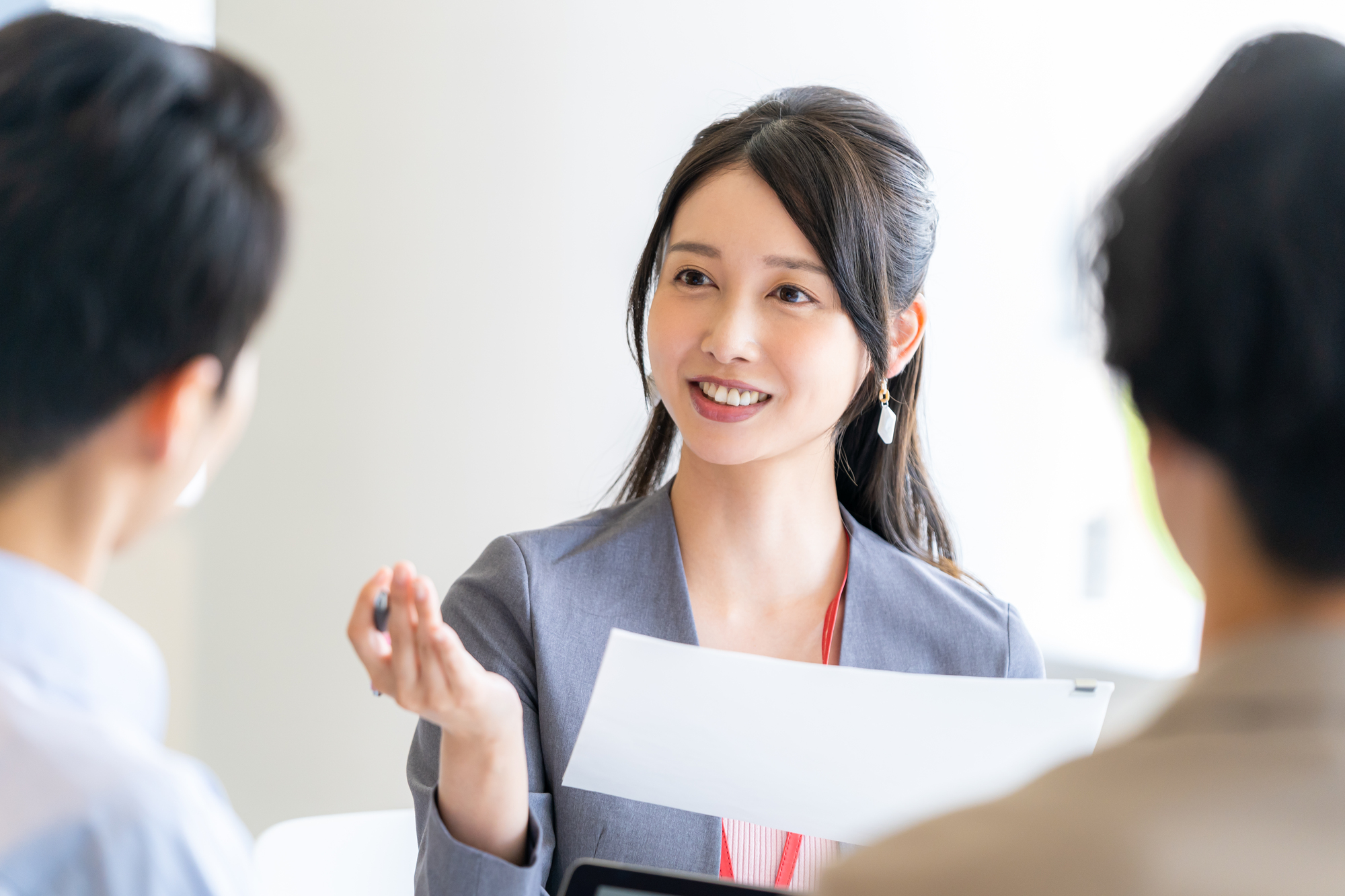 書類を手に説明する女性ビジネスパーソン
