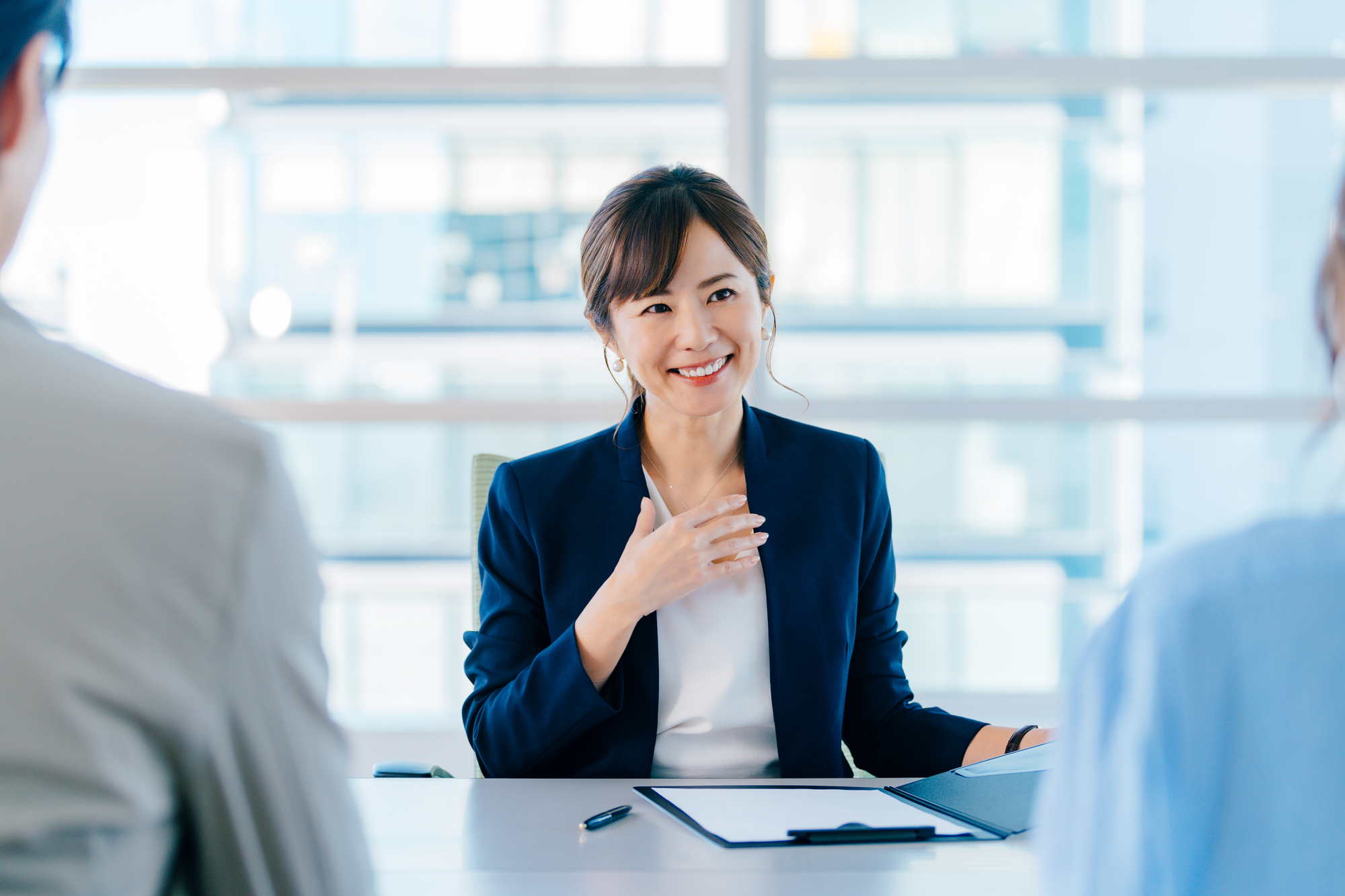 書類を元に説明する女性ビジネスパーソン
