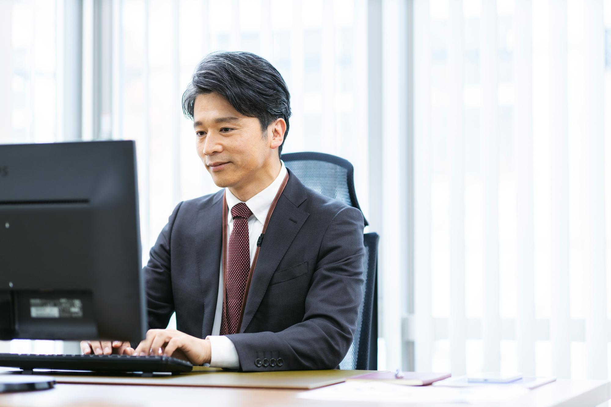 パソコンを操作するスーツの男性