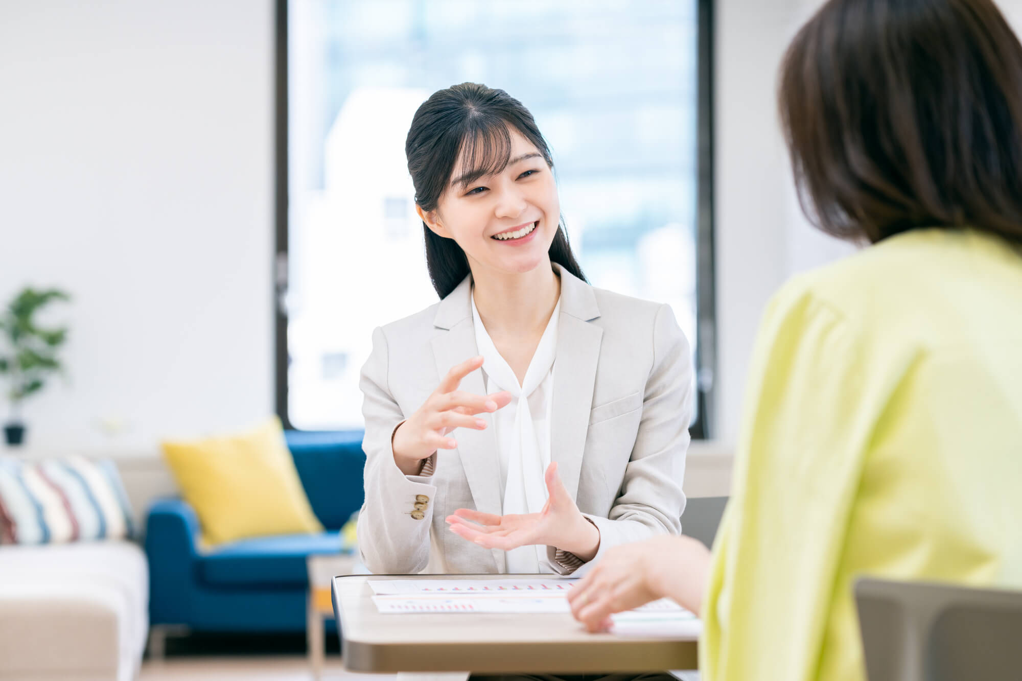 書類を元に説明する女性ビジネスパーソン
