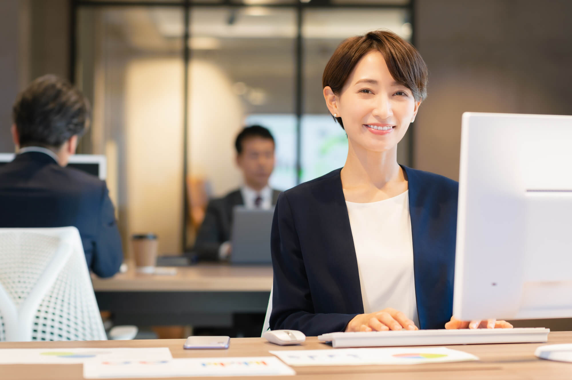 パソコンを操作しながら笑顔を見せる女性ビジネスパーソン