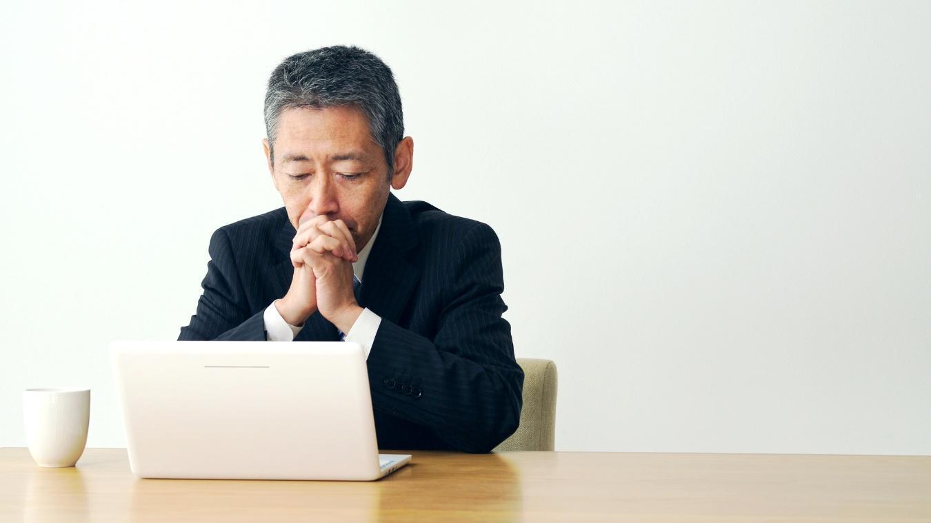 真剣な表情でパソコン画面を見つめる男性