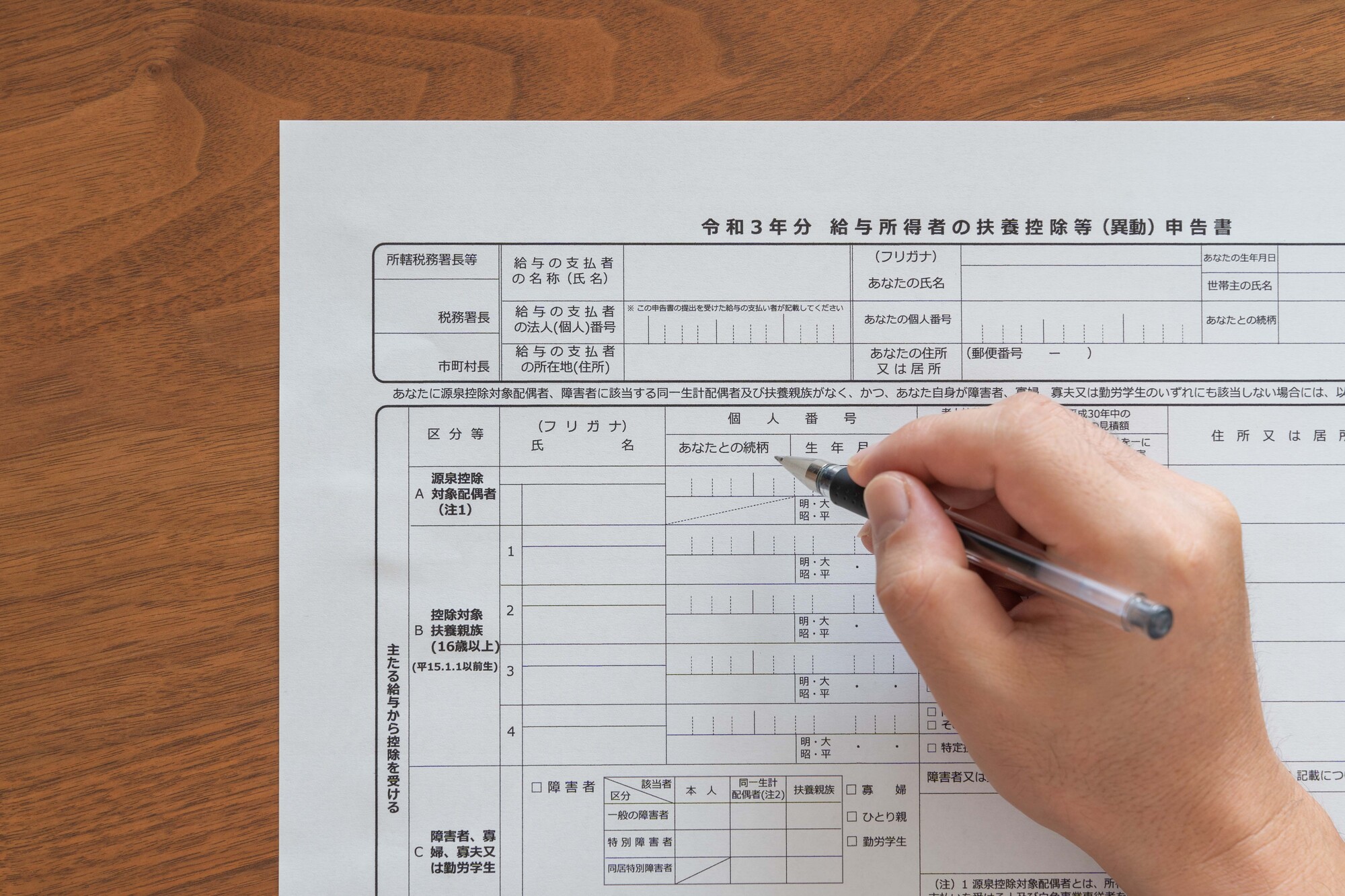 「給与所得者の扶養控除等（異動）申告書」を記入しようとする手元