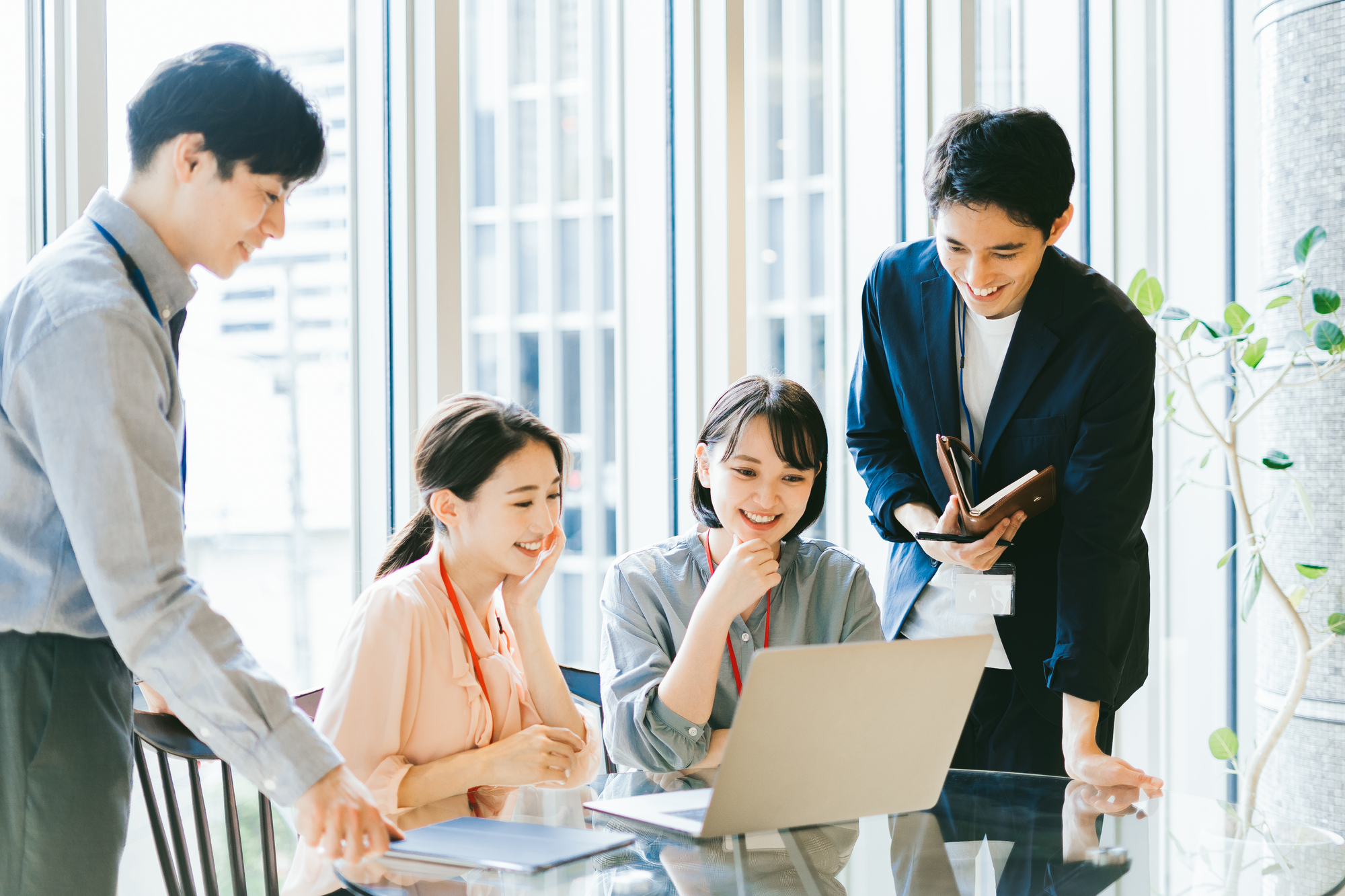 笑顔でミーティングをする4人のビジネスパーソン