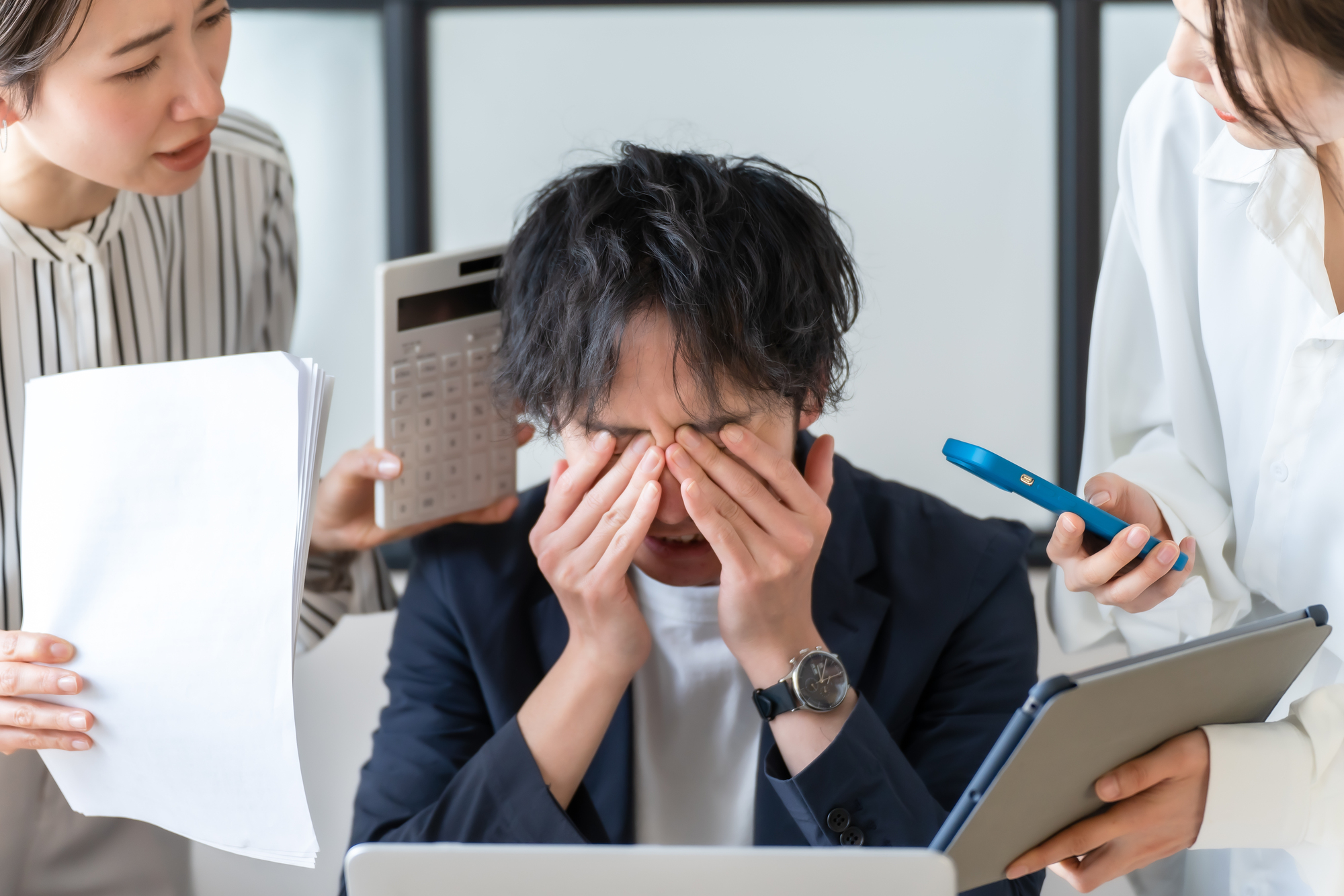 2人の同僚から詰め寄られて困っているビジネスパーソン