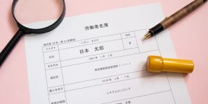 労働者名簿と虫眼鏡・ペン・印鑑
