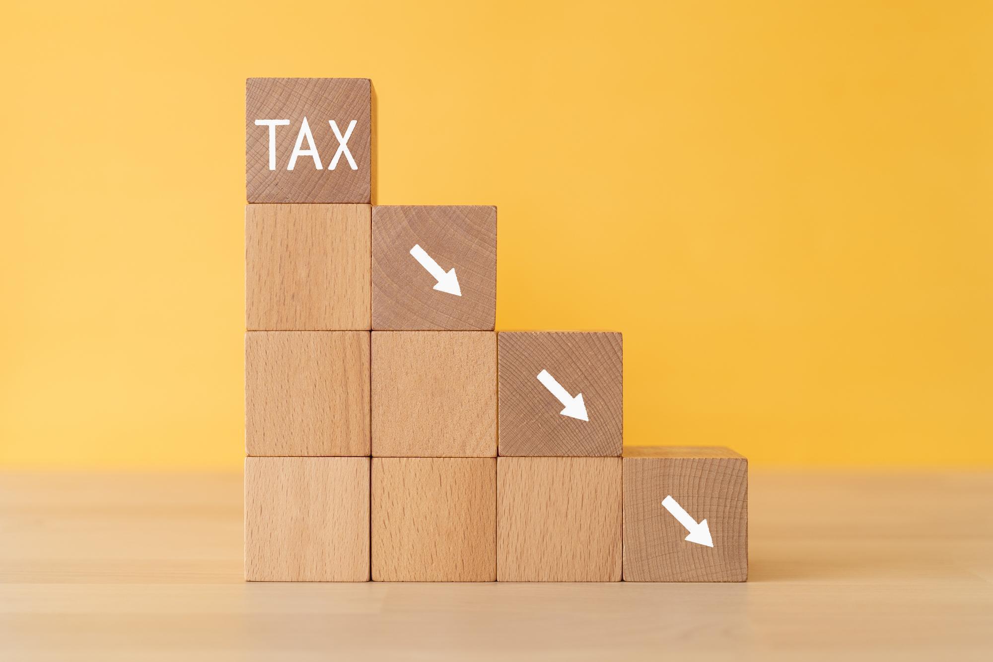TAXと書かれた木のブロックと、斜め下の矢印が書かれた木のブロック