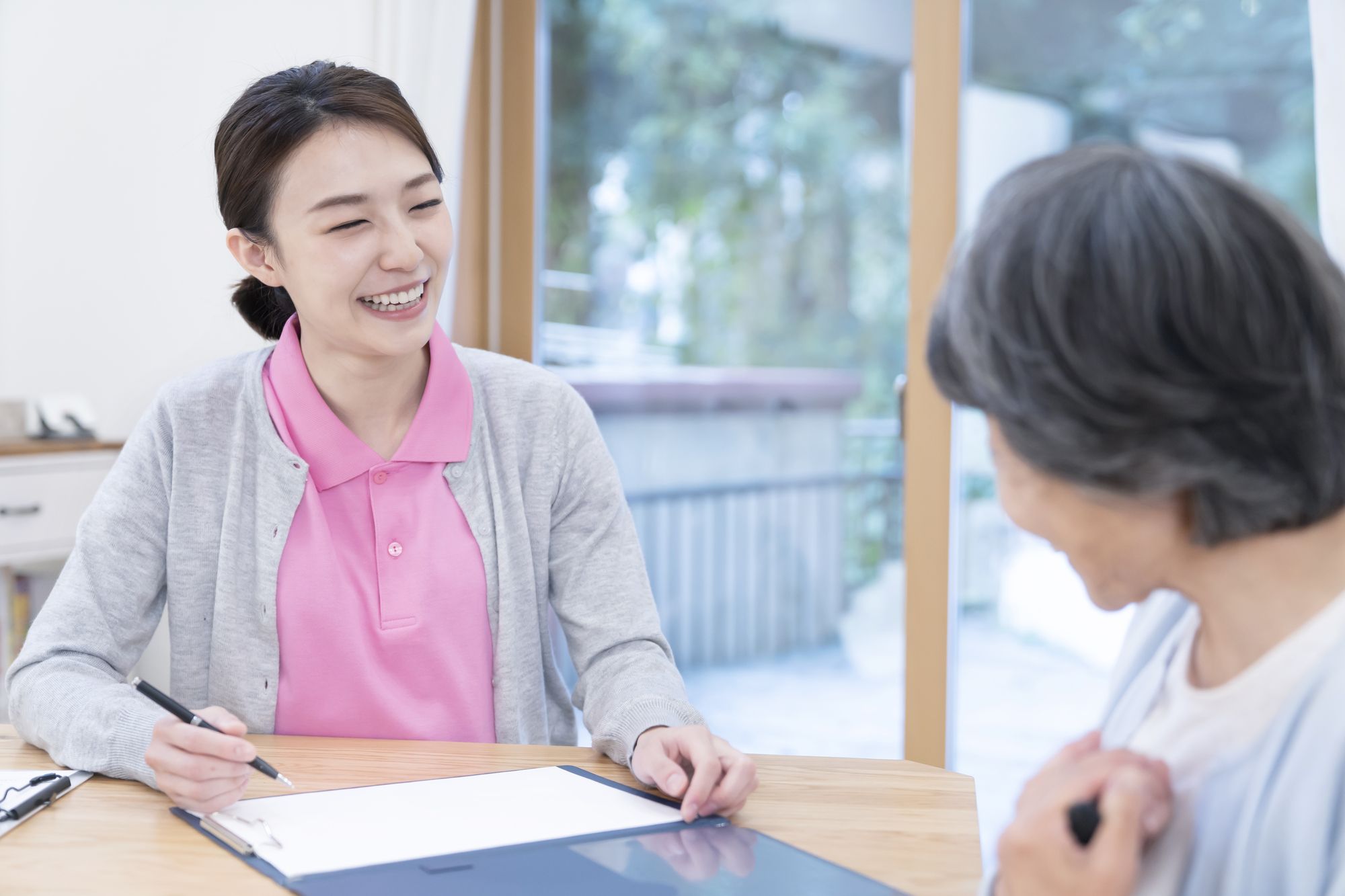 笑顔でシニア女性と話すケアマネージャー