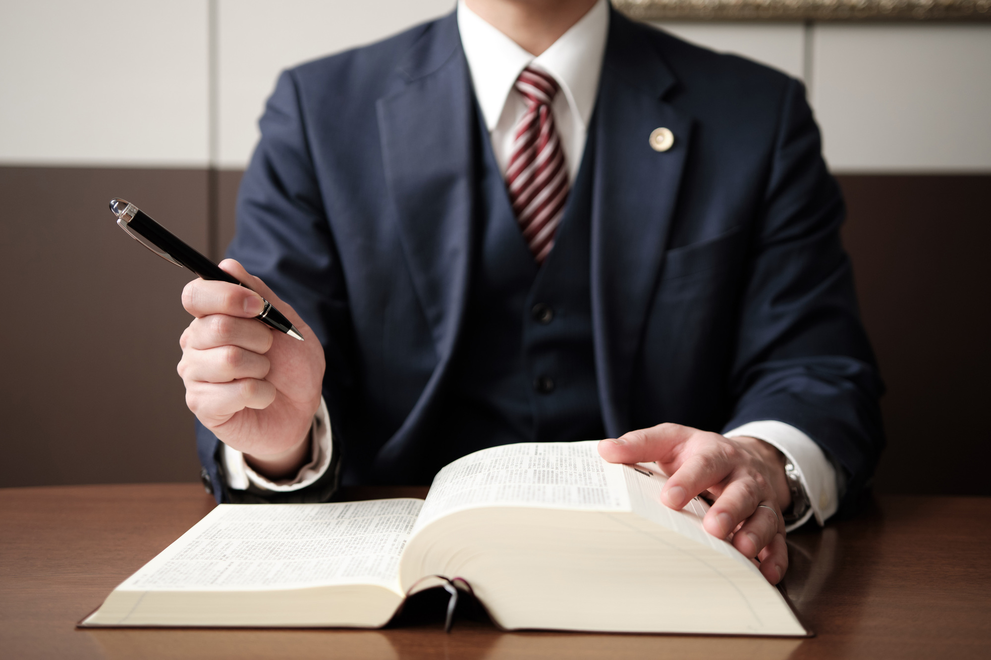 六法全書を開いてペンを持つ弁護士